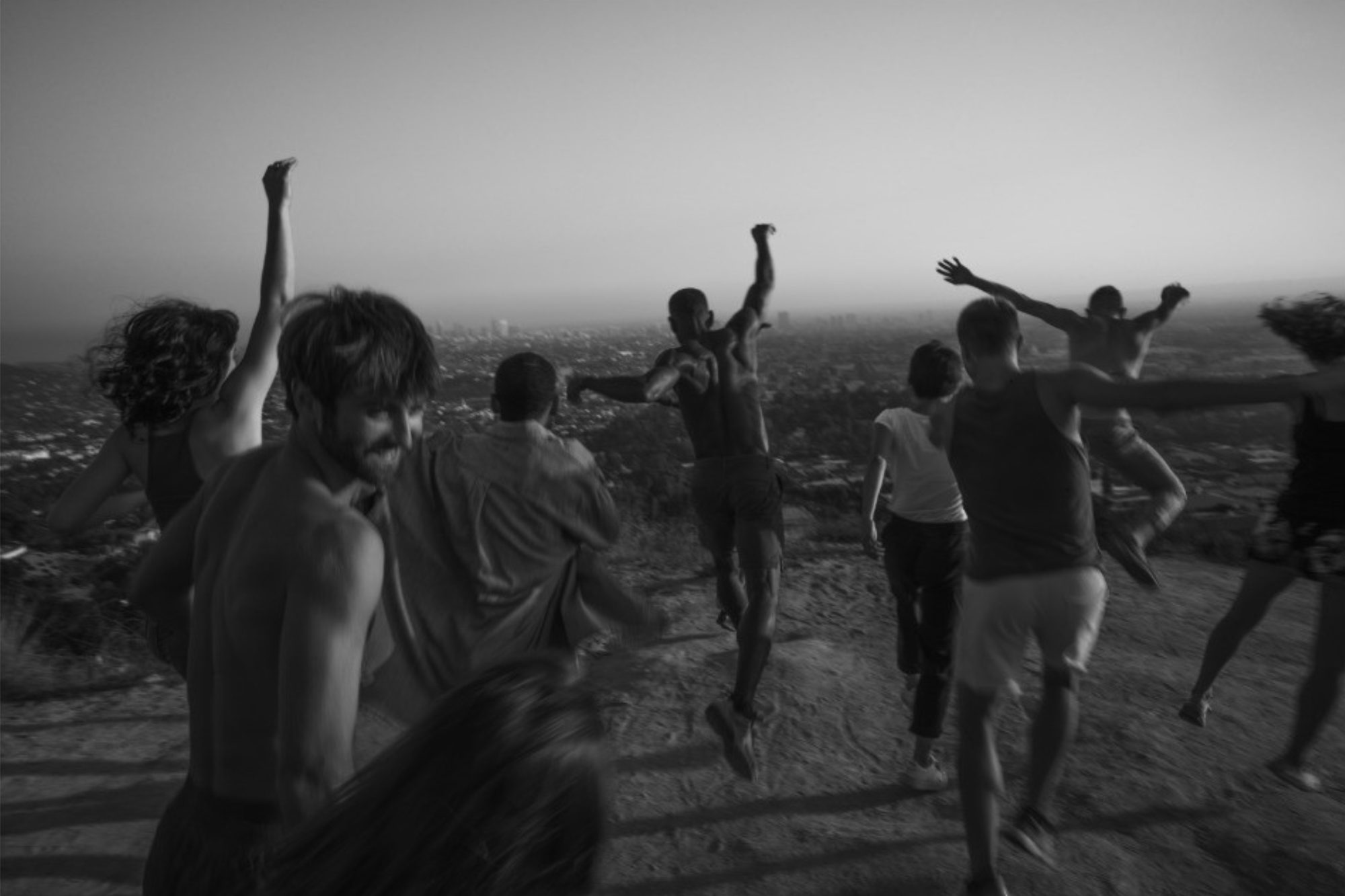 Group running toward the view above Los Angeles at dusk