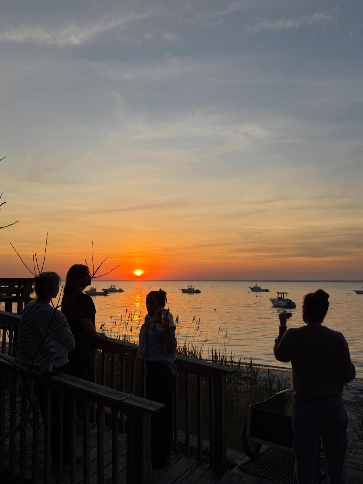 Sunset over the bay at the Fire Island retreat, the group on a deck