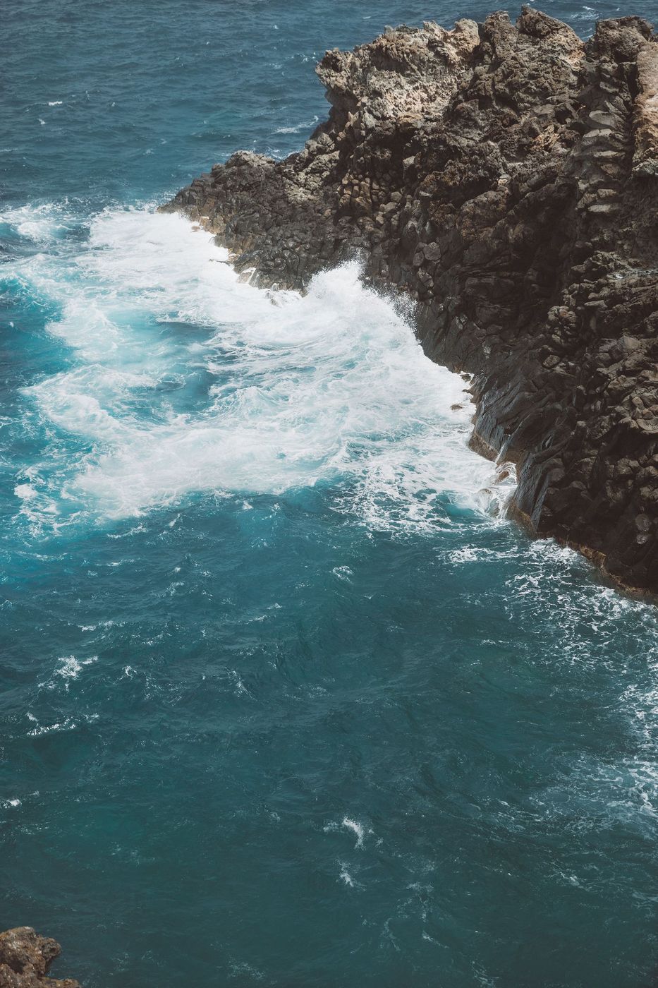 Volcanic coastline of Pantelleria, waves breaking against dark rock